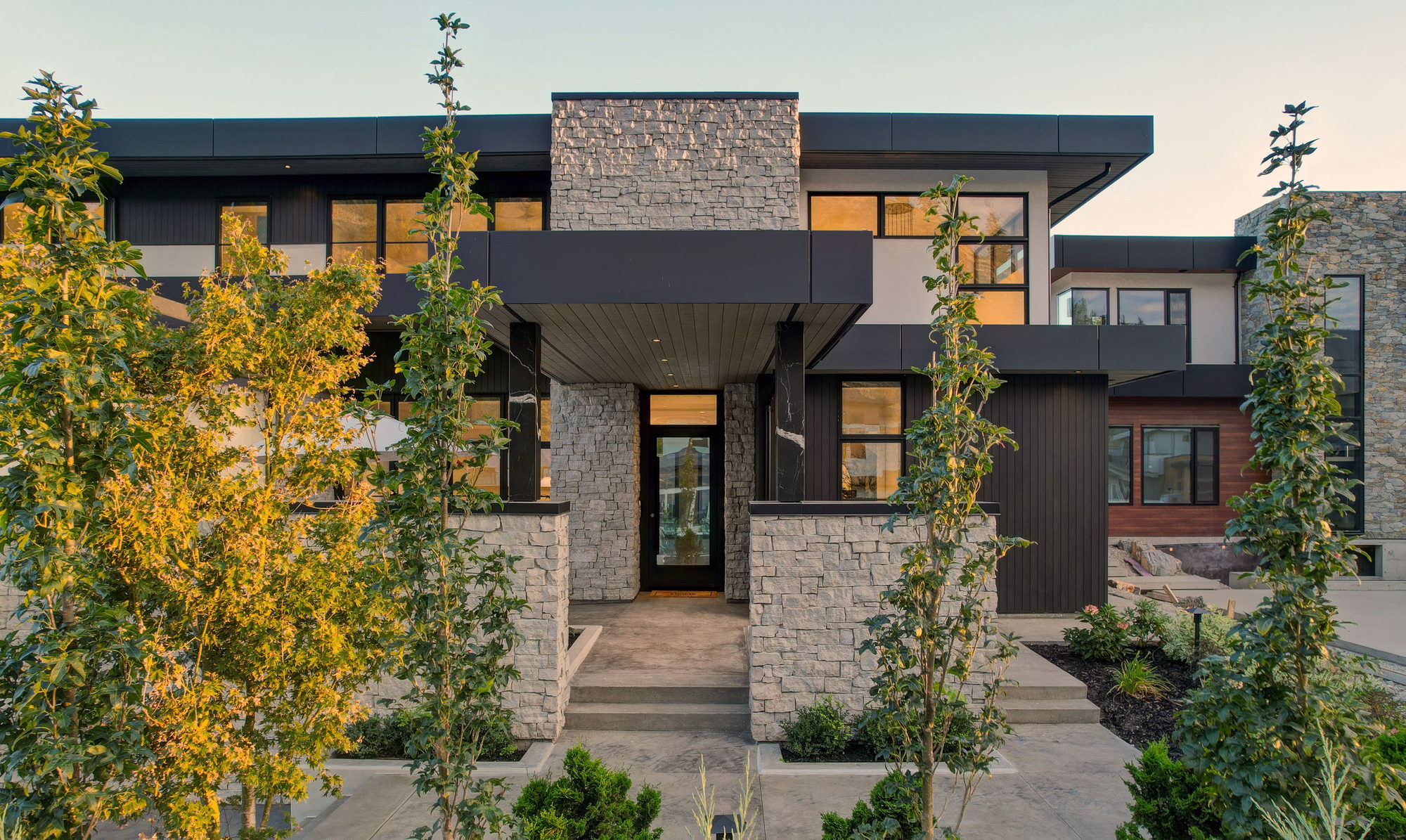 Modern hillside custom home facade with stone entry, Palermo Homes portfolio